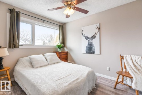 The room features a window with natural light, a ceiling fan, and hardwood-style flooring - 10504 60 Street, Edmonton, AB - Indoor Photo Showing Bedroom