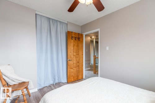 Bedroom featuring a ceiling fan with integrated lighting, wood flooring, and light grey walls - 10504 60 Street, Edmonton, AB - Indoor Photo Showing Bedroom