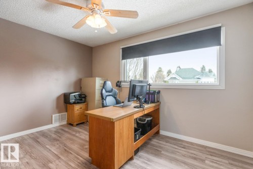 This room features wood-look flooring, a ceiling fan, and a window with a roller blind - 10504 60 Street, Edmonton, AB - Indoor Photo Showing Office
