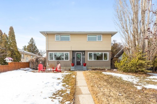 This property features a two-story exterior with light-colored siding and a contrasting darker lower level - 10504 60 Street, Edmonton, AB - Outdoor