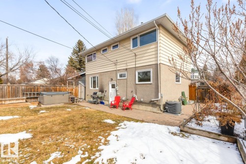 The property features a two-story exterior with beige siding on the upper level and a textured finish on the lower level - 10504 60 Street, Edmonton, AB - Outdoor
