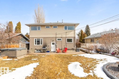 The property features a spacious backyard with a patio area, a hot tub, and a well-maintained lawn - 10504 60 Street, Edmonton, AB - Outdoor With Exterior