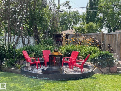 The property features a well-maintained yard with a lawn and mature trees - 10504 60 Street, Edmonton, AB - Outdoor