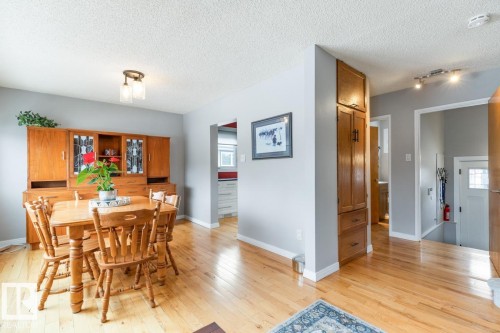 This interior features hardwood flooring and light gray walls throughout - 10504 60 Street, Edmonton, AB - Indoor Photo Showing Dining Room