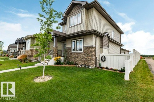 This property features a well-maintained lawn, a paved walkway, and a white picket fence - 2 Wingate Way, Fort Saskatchewan, AB - Outdoor