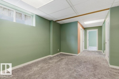 Spacious room featuring light green walls, a window, and gray carpet flooring - 2 Wingate Way, Fort Saskatchewan, AB - Indoor