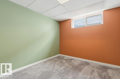 This room features contrasting wall colors, a drop ceiling, and a window - 2 Wingate Way, Fort Saskatchewan, AB - Indoor Photo Showing Other Room
