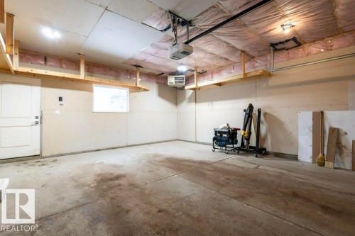 The garage features exposed ceiling insulation, overhead shelving, and a window - 2 Wingate Way, Fort Saskatchewan, AB - Indoor Photo Showing Garage