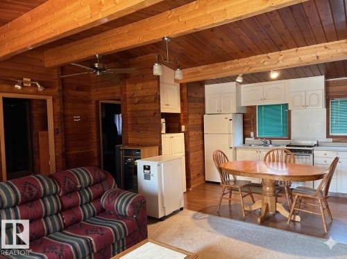 Open-concept living area featuring wood-paneled walls and ceiling with exposed wood beams - 1040 &1040 A&B Mitchell Beach Beach, Rural Leduc County, AB 