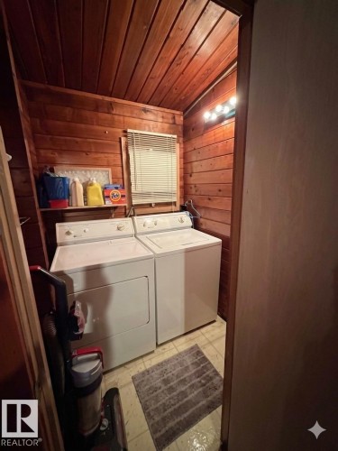 Utility area featuring wood paneling throughout, a window with blinds, and built-in overhead lighting - 1040 &1040 A&B Mitchell Beach Beach, Rural Leduc County, AB 