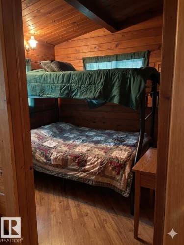 Room featuring wood-finish flooring, wood-paneled walls, and an angled wood-paneled ceiling with an exposed beam - 1040 &1040 A&B Mitchell Beach Beach, Rural Leduc County, AB 