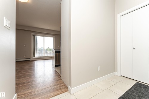 The property entrance features light-colored walls, complementing the light-toned tiled flooring, and a white bi-fold door - 313 10418 81 Avenue, Edmonton, AB - Indoor Photo Showing Other Room