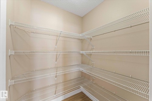 This property features a spacious storage area with extensive white wire shelving, providing ample organizational space - 84 Calvert Wynd, Fort Saskatchewan, AB - Indoor With Storage