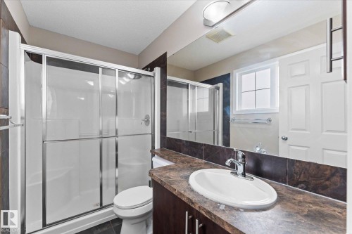 This bathroom features a contemporary vanity with an oval sink and a spacious shower with sliding glass doors - 84 Calvert Wynd, Fort Saskatchewan, AB - Indoor Photo Showing Bathroom