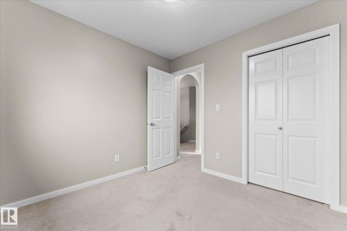 This room features light-colored carpeting, neutral painted walls, and white trim - 84 Calvert Wynd, Fort Saskatchewan, AB - Indoor Photo Showing Other Room