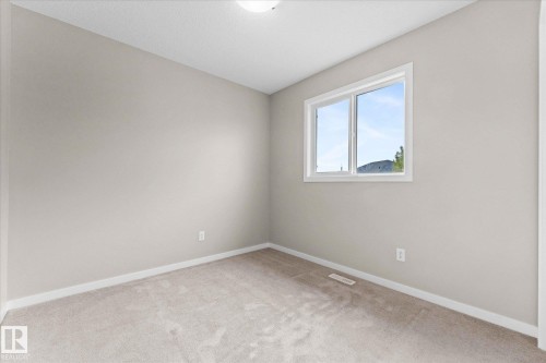 Room with neutral-toned walls, light-colored carpet, and a window providing natural light - 84 Calvert Wynd, Fort Saskatchewan, AB - Indoor Photo Showing Other Room