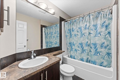 Bathroom featuring a vanity with an oval sink, a toilet, and a bathtub with a shower - 84 Calvert Wynd, Fort Saskatchewan, AB - Indoor Photo Showing Bathroom