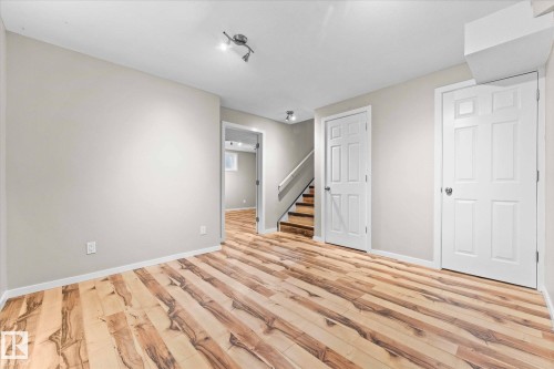 Living area featuring light-colored walls and hardwood flooring - 84 Calvert Wynd, Fort Saskatchewan, AB - Indoor Photo Showing Other Room