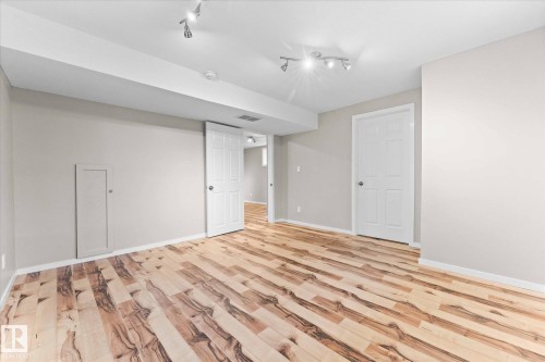 The property features light-toned hardwood flooring, recessed lighting, and neutral-colored walls - 84 Calvert Wynd, Fort Saskatchewan, AB - Indoor Photo Showing Other Room