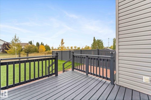 The property features a spacious wooden deck with dark railings, providing an outdoor entertaining area - 84 Calvert Wynd, Fort Saskatchewan, AB - Outdoor With Deck Patio Veranda With Exterior