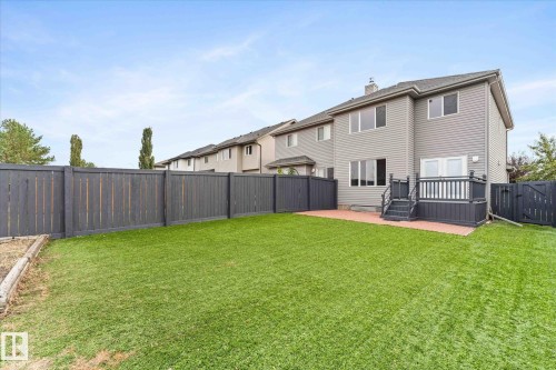 The property features a spacious yard with a lush green lawn, complemented by a private fence - 84 Calvert Wynd, Fort Saskatchewan, AB - Outdoor