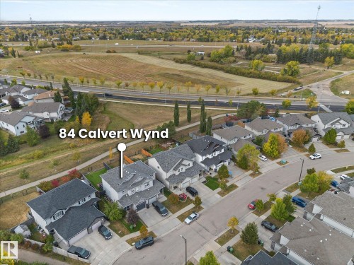 Aerial view showcasing the property situated within a residential area, featuring a street and surrounding green spaces - 84 Calvert Wynd, Fort Saskatchewan, AB - Outdoor With View
