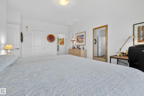 A white-painted room with light-colored flooring and several white doors - 318 9820 165 Street, Edmonton, AB - Indoor Photo Showing Bedroom