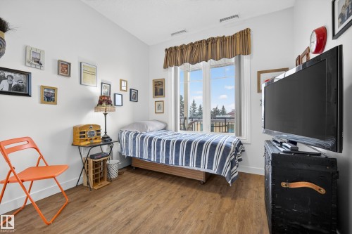 This room features light-colored walls and wood-style flooring - 318 9820 165 Street, Edmonton, AB - Indoor Photo Showing Bedroom