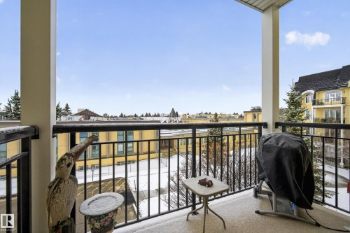 Enjoy outdoor living on the balcony with a black metal railing and views of the surrounding neighborhood buildings - 318 9820 165 Street, Edmonton, AB - Outdoor With Exterior