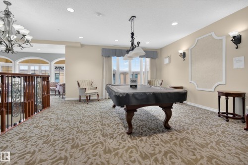 This inviting room features patterned carpeting, recessed lighting, and a billiard table - 318 9820 165 Street, Edmonton, AB - Indoor Photo Showing Other Room