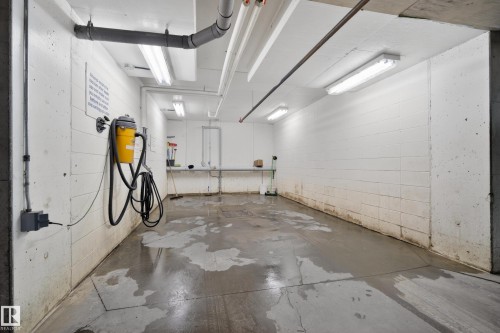 Utility room with concrete flooring, white block walls, and overhead fluorescent lighting - 318 9820 165 Street, Edmonton, AB - Indoor Photo Showing Garage