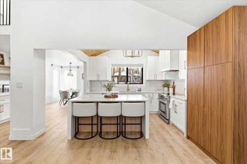 The kitchen features light-toned flooring, white cabinetry, and stainless steel appliances - 38 Woodcrest Avenue, St. Albert, AB - Indoor Photo Showing Kitchen With Upgraded Kitchen