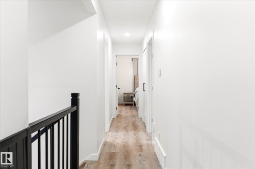 The hallway features light-toned wood flooring, clean white walls, and recessed lighting - 38 Woodcrest Avenue, St. Albert, AB - Indoor Photo Showing Other Room