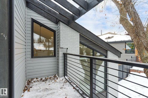 The property features light gray siding and a light gray brick facade, with prominent black trim around the windows and roofline - 38 Woodcrest Avenue, St. Albert, AB - Outdoor With Exterior