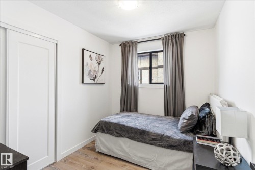 This room features bright white walls, light wood flooring, and a window with curtains - 38 Woodcrest Avenue, St. Albert, AB - Indoor Photo Showing Bedroom