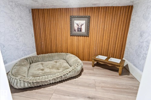 An alcove features wood paneling and wallpapered walls, with light-toned flooring - 38 Woodcrest Avenue, St. Albert, AB - Indoor