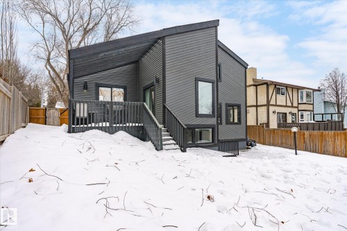 The property features a dark-toned exterior with a modern architectural design, including an angled roofline and varied window shapes - 38 Woodcrest Avenue, St. Albert, AB - Outdoor