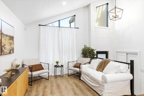 Living area featuring high ceilings, light wood-style flooring, and large windows that provide abundant natural light - 38 Woodcrest Avenue, St. Albert, AB - Indoor