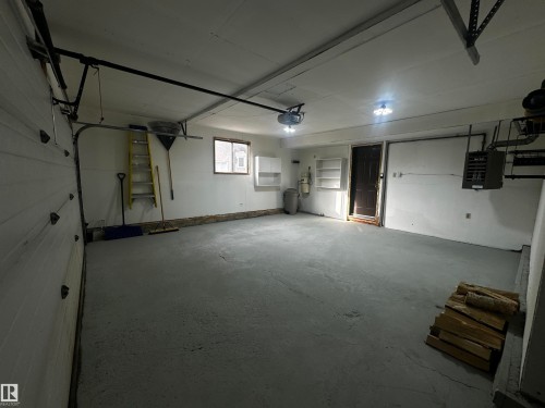 Spacious garage featuring a concrete floor, overhead lighting, and a window for natural light - 38 Woodcrest Avenue, St. Albert, AB - Indoor Photo Showing Garage