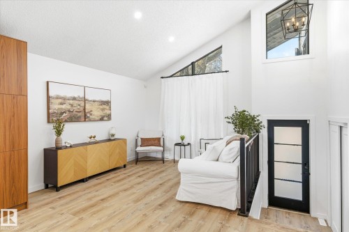 This bright interior space features wood-style flooring, a vaulted ceiling, and recessed lighting - 38 Woodcrest Avenue, St. Albert, AB - Indoor