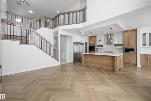 This property features a spacious open-concept design with light wood herringbone flooring - 236 Kinglet Boulevard Nw, Edmonton, AB - Indoor Photo Showing Kitchen