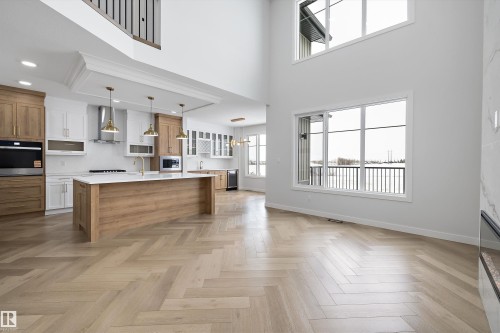 Spacious open concept living area featuring a kitchen with an island, light wood cabinetry, white countertops, and stainless steel appliances - 236 Kinglet Boulevard Nw, Edmonton, AB - Indoor Photo Showing Kitchen