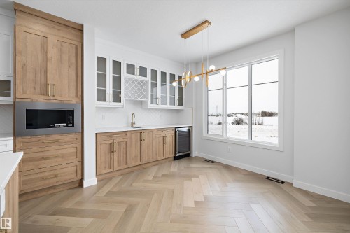 This area features light-toned herringbone flooring and a contemporary chandelier - 236 Kinglet Boulevard Nw, Edmonton, AB - Indoor