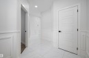 The property features a bright hallway with white wainscoting and white tile flooring - 236 Kinglet Boulevard Nw, Edmonton, AB  - Indoor Photo Showing Other Room 
