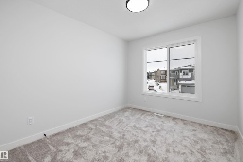 This room features light grey carpeting, white walls, and a window with white trim - 236 Kinglet Boulevard Nw, Edmonton, AB - Indoor Photo Showing Other Room