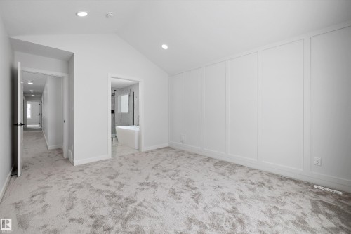 Spacious room featuring vaulted ceilings with recessed lighting, light-colored carpet, and a decorative paneled accent wall - 236 Kinglet Boulevard Nw, Edmonton, AB - Indoor Photo Showing Other Room