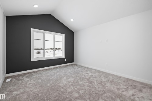 This room features a vaulted ceiling, recessed lighting, and a large window providing natural light - 236 Kinglet Boulevard Nw, Edmonton, AB - Indoor Photo Showing Other Room