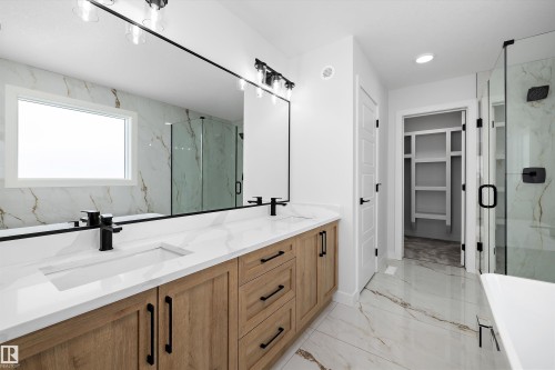 This bathroom features a double vanity with light wood cabinetry, white countertops, and black hardware - 236 Kinglet Boulevard Nw, Edmonton, AB - Indoor Photo Showing Bathroom
