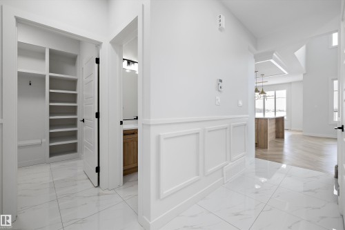Entryway featuring white tile flooring, wainscoting, and a built-in storage area with shelving and hooks - 236 Kinglet Boulevard Nw, Edmonton, AB - Indoor Photo Showing Other Room