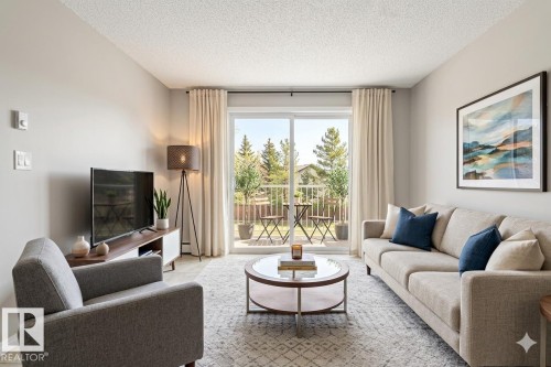 Bright living area featuring a sliding glass door leading to an outdoor balcony - 224 3425 19 Street Nw, Edmonton, AB - Indoor Photo Showing Living Room